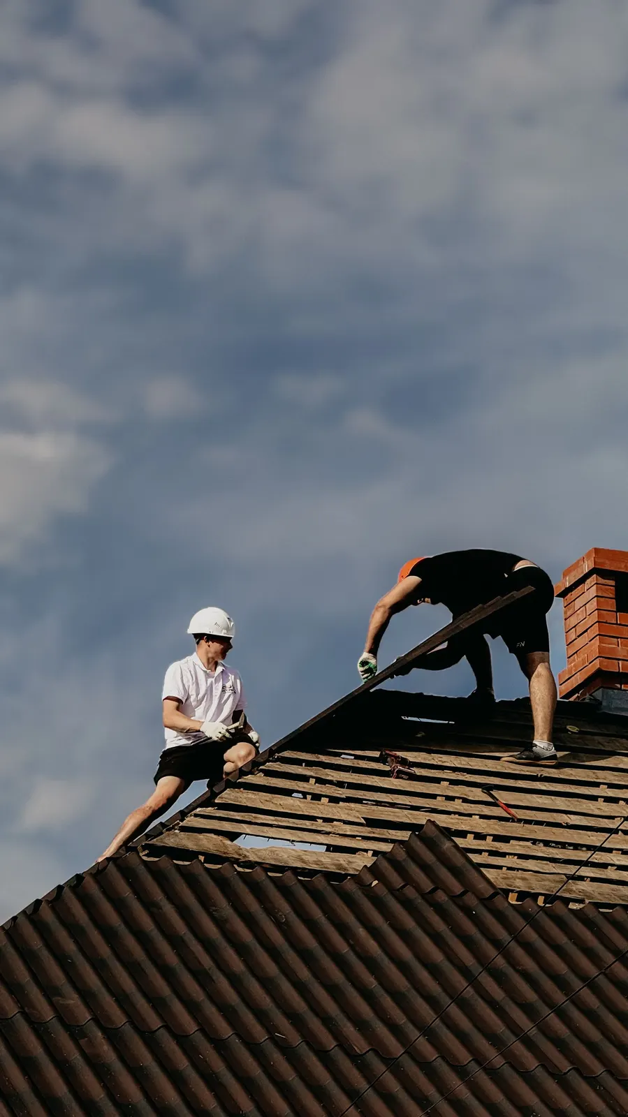 Roofer repairing roof tiles on a house in Dudley